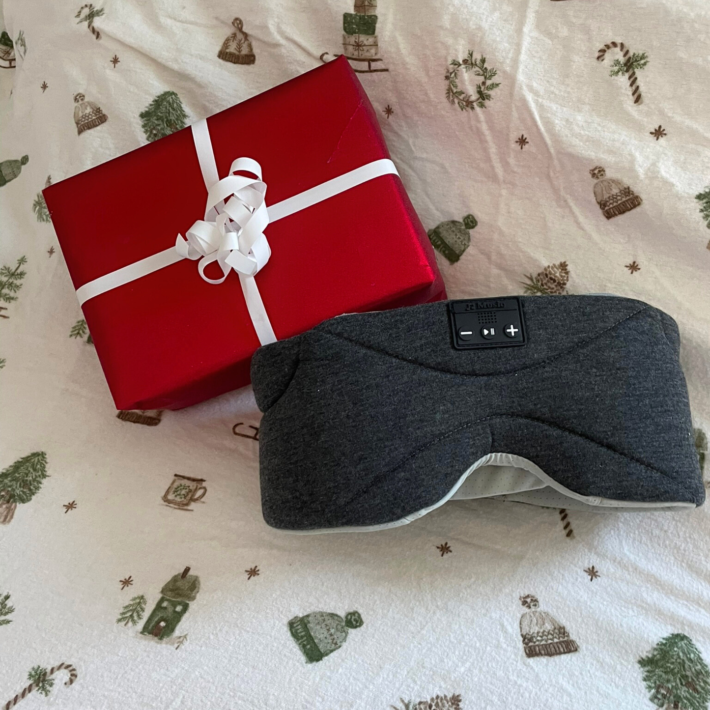 Dreamli sovemaske som julegave – masken ligger på sengen med julesengetøy.