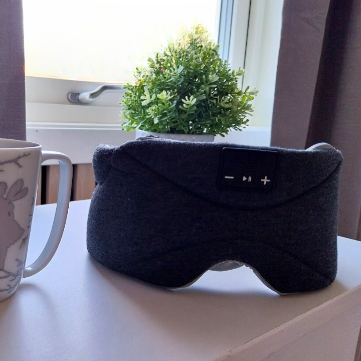 Dreamli sovemaske på nattbord i dagslys – komfortabel maske klar for ro og dypere søvn.